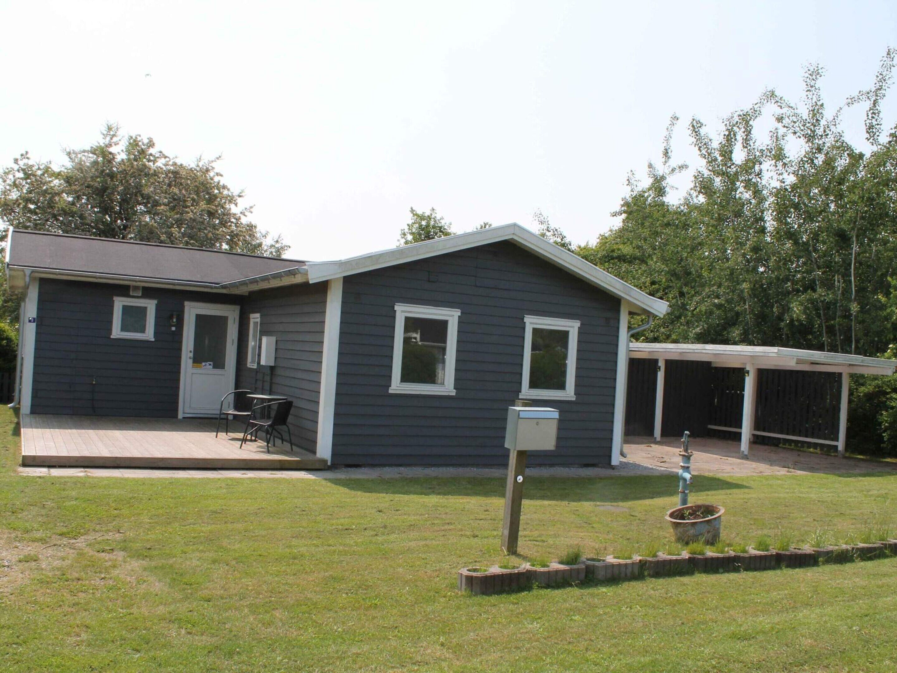 A two-story house with a covered patio and a fenced yard.
