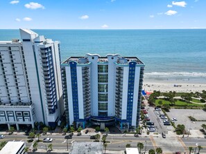 A high-rise hotel with multiple floors, a central entrance, and a view of the beach. - Sun & Surf: 1-BR City View Condo in Myrtle Beach (Myrtle Beach)