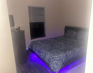 Tabla de planchar con plancha, internet y ropa de cama