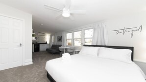 A modern hotel room with a large bed, a ceiling fan, a desk, and a view of the outside. - Modern Retreat w/ Fire Pit & Parking (Annapolis)