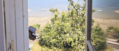 Une pièce avec vue sur la plage, une fenêtre et une porte.