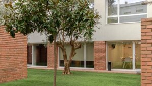 A modern building with a brick exterior, large windows, and a well-maintained lawn. - Magnolia Suites & Stays :Standard Suite (Porto)
