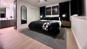 Ein modernes Schlafzimmer mit Bett, Deckenventilator, großem Spiegel, Kleiderschrank und einem Fenster mit Vorhängen.