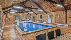 An indoor swimming pool with wooden walls and ceiling, surrounded by seating areas. - Unique Perfect for Families/Groups+Indoor Pool (Wurtsboro)