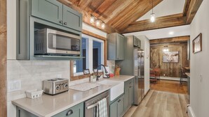 A kitchen with green cabinets, a stainless steel microwave, a toaster, and a sink. - Unique Perfect for Families/Groups+Indoor Pool (Wurtsboro)