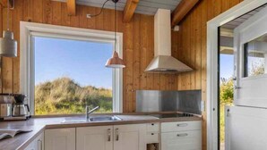 Une cuisine moderne avec des murs en bois, une grande fenêtre et un four encastré.