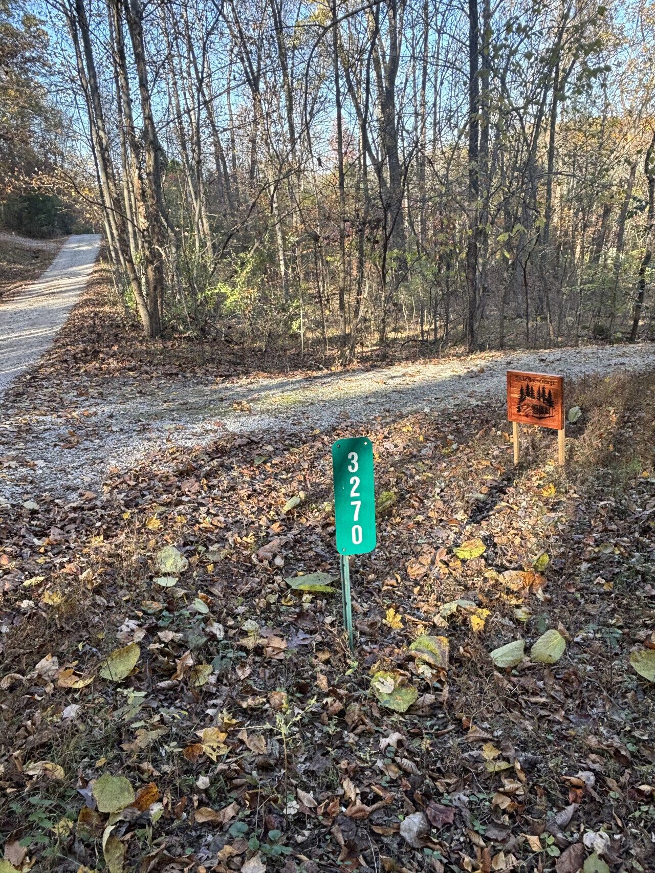 A green sign with the number 3270 in a forested area.