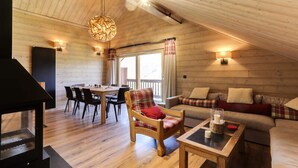Ein gemütliches Holzinterieur mit Essbereich, einer Couch und einem Kamin.