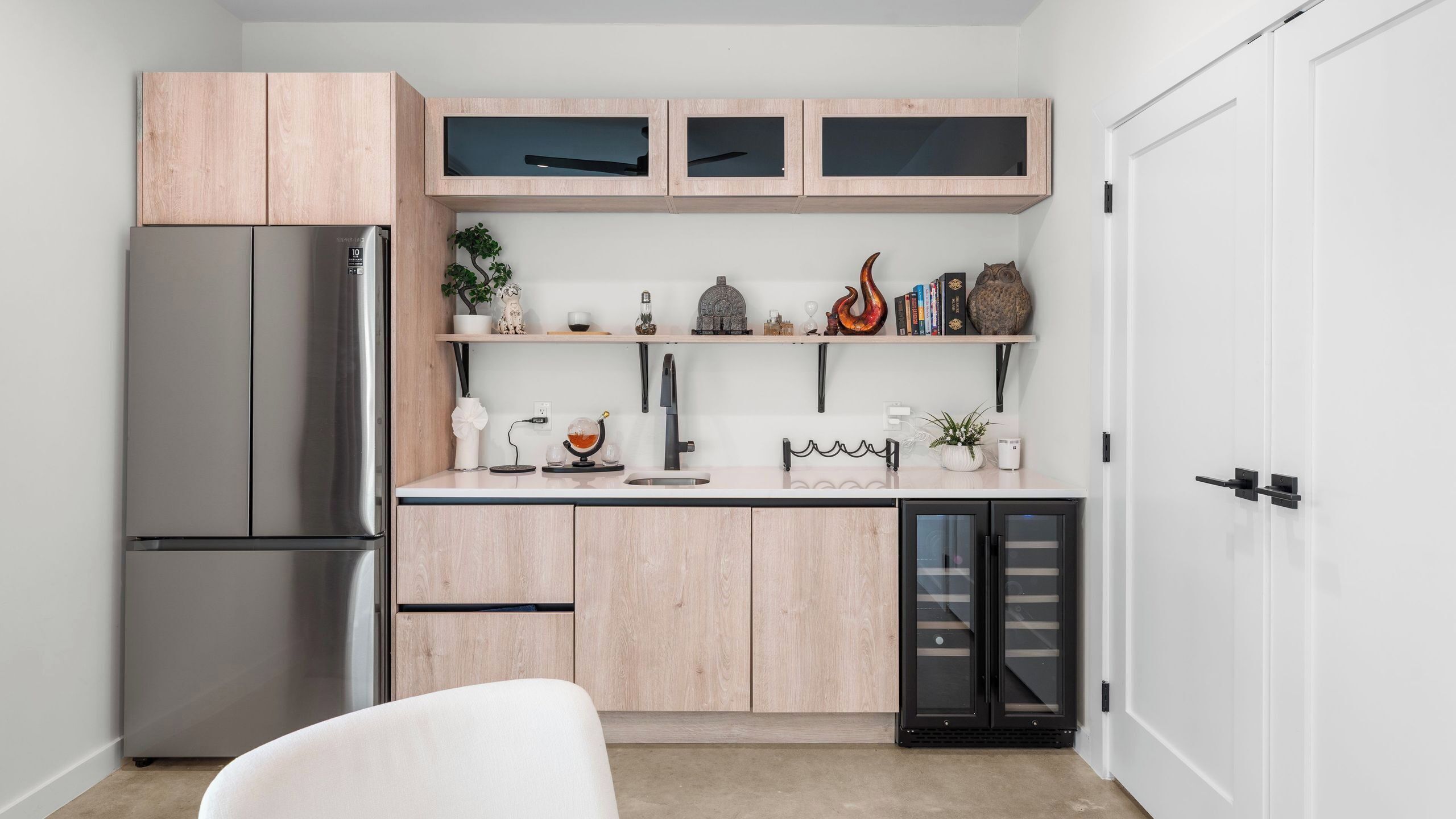 Eine moderne Küche mit einem Edelstahl-Kühlschrank, Holzschränken und einem Geschirrspüler.