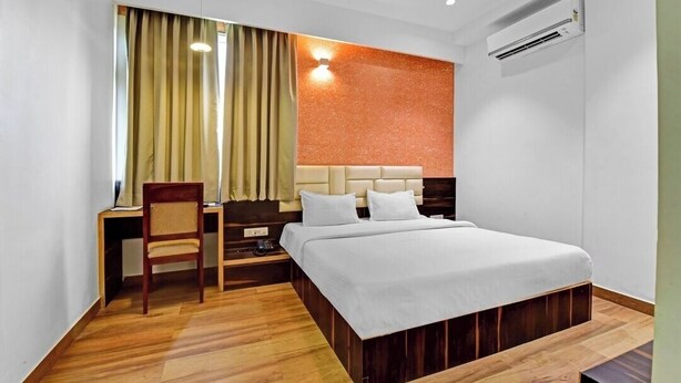 Une chambre d’hôtel équipée d’un lit, d’un bureau, d’une chaise et d’un appareil de climatisation.