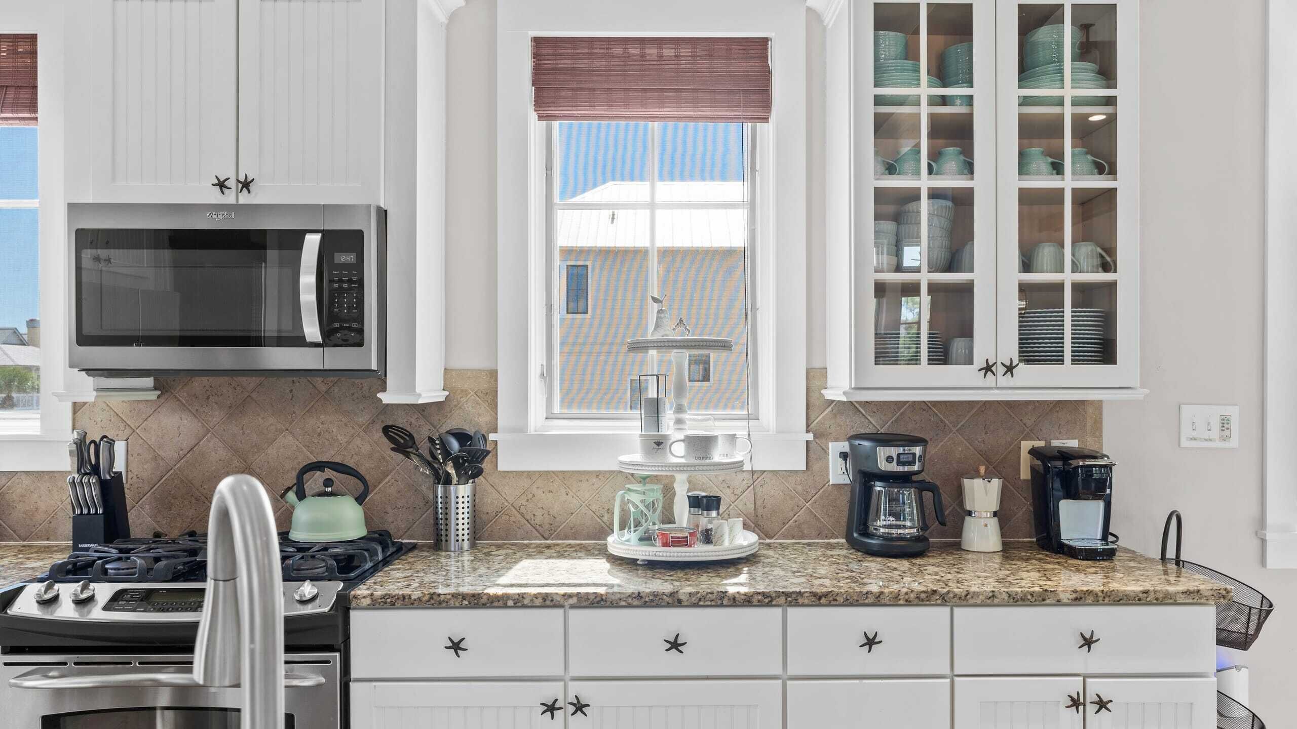 A modern kitchen with a built-in microwave, stove, and coffee maker.