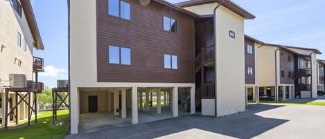 A multi-story residential building with a covered outdoor area and a visible balcony.