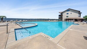 Une piscine dont la profondeur est indiqu ée à 3 pieds et demi, un espace de détente avec des chaises longues et un bâtiment doté d’un balcon.