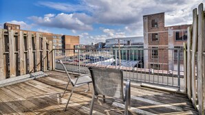 A rooftop deck with a view of a cityscape, including a large building and a parking lot. - 2-Story Townhouse in the Heart of Downtown (Cleveland)