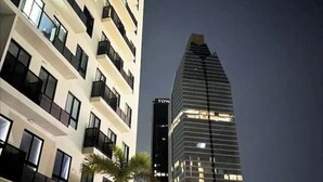 Een modern hoog gebouw met een opvallend ‘TOW’ bord, met meerdere verdiepingen met balkons en grote ramen.