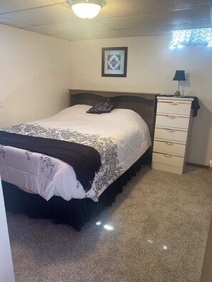A bedroom with a bed, a dresser, a framed picture on the wall, and a ceiling light. - Cozy, spacious house located near historic downtown near shopping and dining. (Watertown)