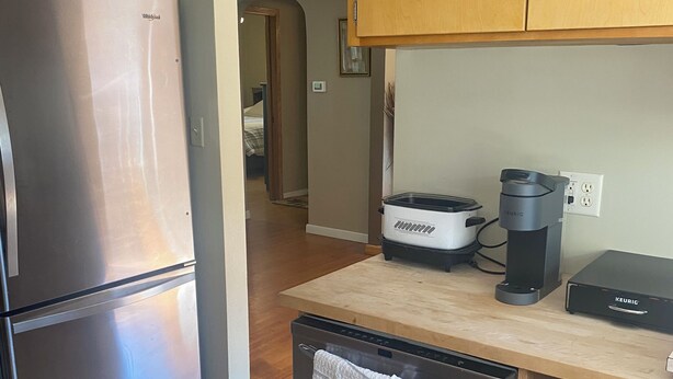 A kitchen with a stainless steel refrigerator, a coffee maker, and a dishwasher. - Cozy, spacious house located near historic downtown near shopping and dining. (Watertown)