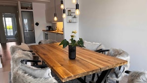 Ein moderner Essbereich mit einem Holztisch, bequemen Stühlen und einer Vase mit Blumen.