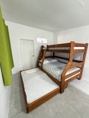 A bunk bed with a ladder, a white door, and a green curtain. - A block from Chipipe beach Salinas cost studio for 5  Salinas with AC (Salinas)