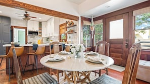 A dining area with a round table, chairs, and a vase of flowers.