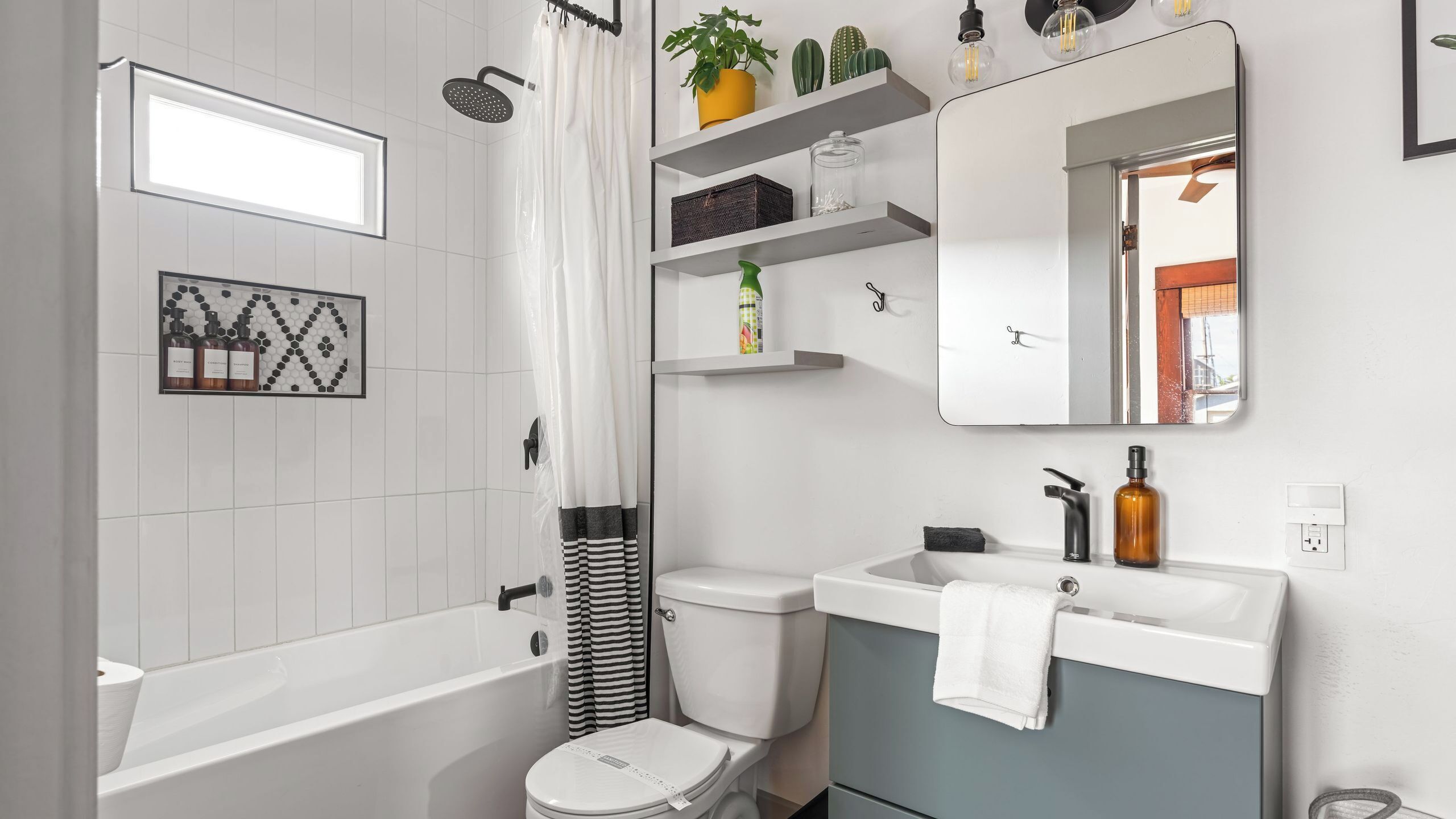 Uma casa de banho moderna com banheira, sanita, lavatório e chuveiro.