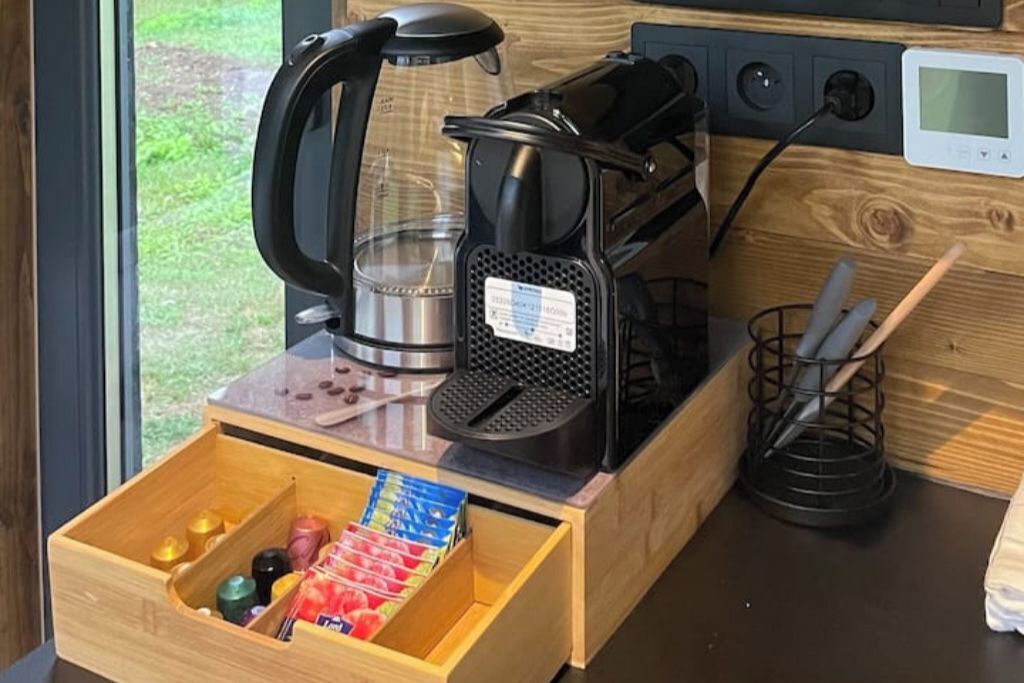 Una moka, un cassetto con diversi oggetti e un piano di lavoro in legno.