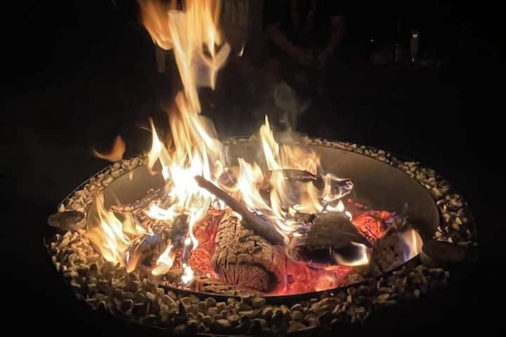 A fire pit with logs and flames.