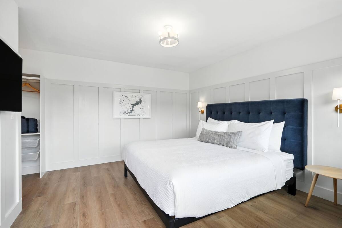 A bedroom with a large bed, a wardrobe, and a bedside table.