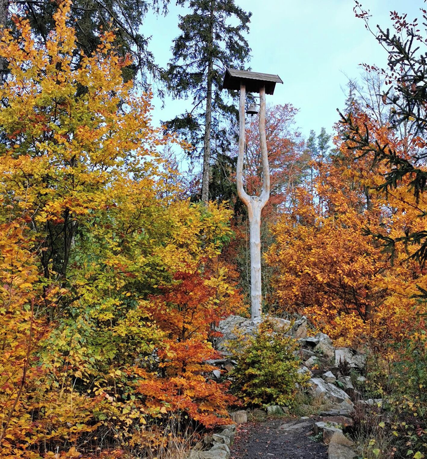 Ein schlanker, hoher Bau mit flacher Spitze, umgeben von Herbstlaub.