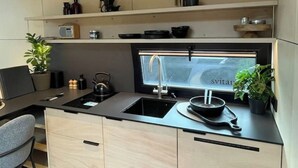 A modern kitchen with a black countertop, a built-in sink, and a window above the sink.