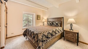 A bedroom with a bed, bedside tables, a window, and a ceiling fan. -   UPDATED CONDO 5 MIN WALK TO QUICKSILVER LIFT & MAIN ST HOTUBS-POOL-NEW FURN! (Breckenridge)