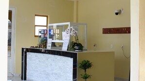 A hotel reception area with a reception desk, a potted plant, and a sign indicating the reception. - Hotel San Jose  (Tepeaca)