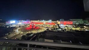 Vista nocturna d'un paisatge urbà amb edificis il·luminats i un carrer animat.