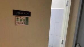 A hallway leading to a garbage room with a green trash bin visible. - Kathy’s Crib 11th flr pool view Shell Residences (Pasay City)