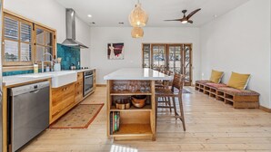 A spacious kitchen with a central island, wooden cabinets, and a built-in oven. - Desert oasis with hot water  outdoor soaking tubs (Joshua Tree)