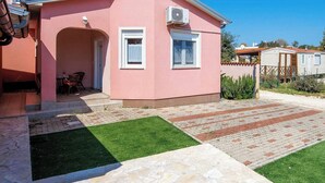 A pink house with a patio, a small garden, and a clear blue sky. - Kuća za odmor Barbariga-Betiga (Vodnjan)