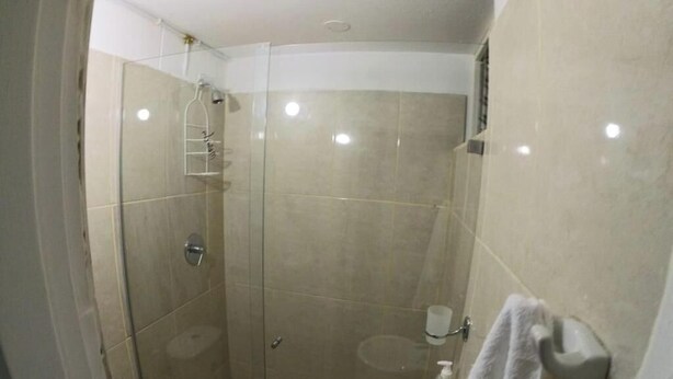 Une salle de bain moderne avec une douche à parois de verre, des toilettes et un lavabo.