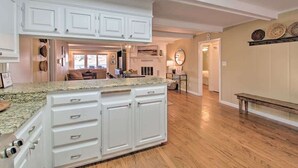 A spacious kitchen with white cabinetry, a granite countertop, and hardwood flooring. - Waterfront Getaway on Lake Hamilton (Lake Hamilton)