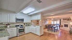 A spacious kitchen with white cabinetry, a granite countertop, and a large island. - Waterfront Getaway on Lake Hamilton (Lake Hamilton)