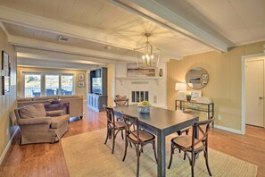 A spacious living area with a dining table, chairs, and a sofa.