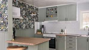 A kitchen with a wooden island, grey cabinets, and a patterned backsplash. - 4 Star Holiday Home in Bralanda (Bralanda)