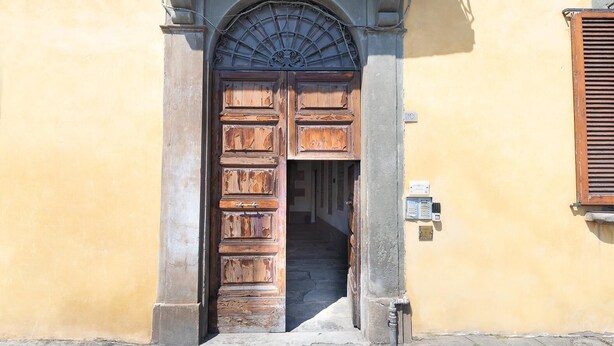 Una puerta de madera con un arco de metal encima, que da a una escalera.