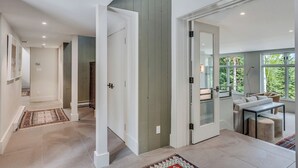 A modern interior with a hallway leading to a dining area with a view of trees. - The Silos by Snowmass Vacations (Snowmass Village)