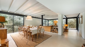 A spacious dining area with a high ceiling, large windows, and a view of the outdoors. - Villa 243 - Charming Villa in a peaceful area (Orbacém)