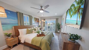 A bedroom with a bed, nightstands, a dresser, a ceiling fan, and a large window with a view of the beach.