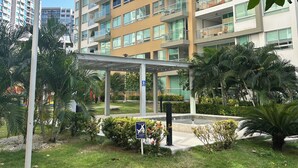 A modern multi-story building with balconies, surrounded by greenery and a covered walkway. - Charming 2-bedroom apartment in delightful Barranquilla with AC (Barranquilla)