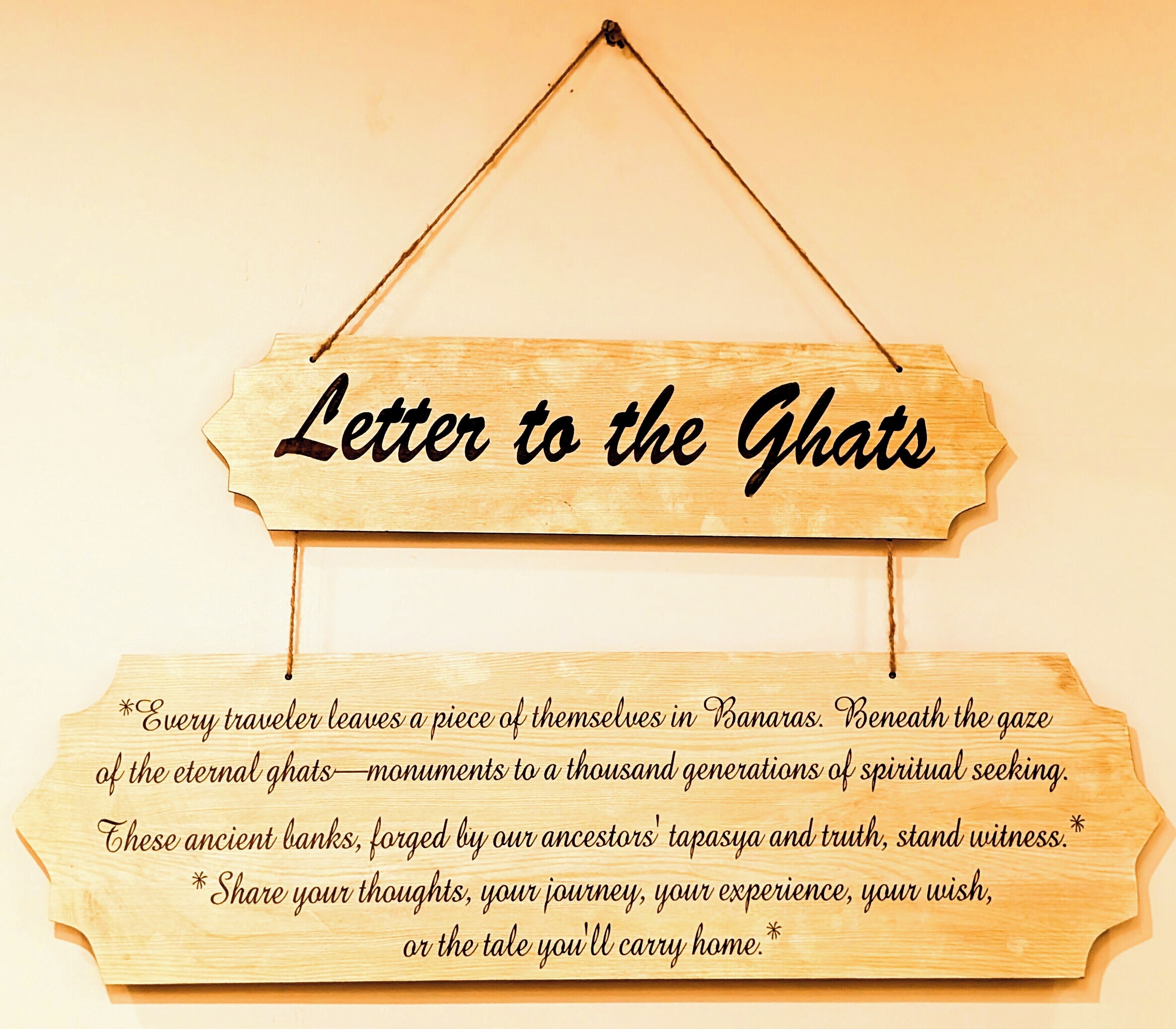 A wooden sign with the text 'Letter to the Ghat' and a message about spiritual seeking and ancestral banks.