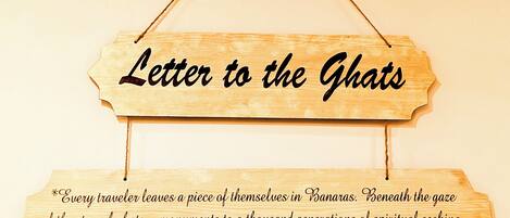 A wooden sign with the text 'Letter to the Ghat' and a message about spiritual seeking and ancestral banks.