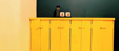 A bathroom with a yellow cabinet, a mirror, and a towel rack.