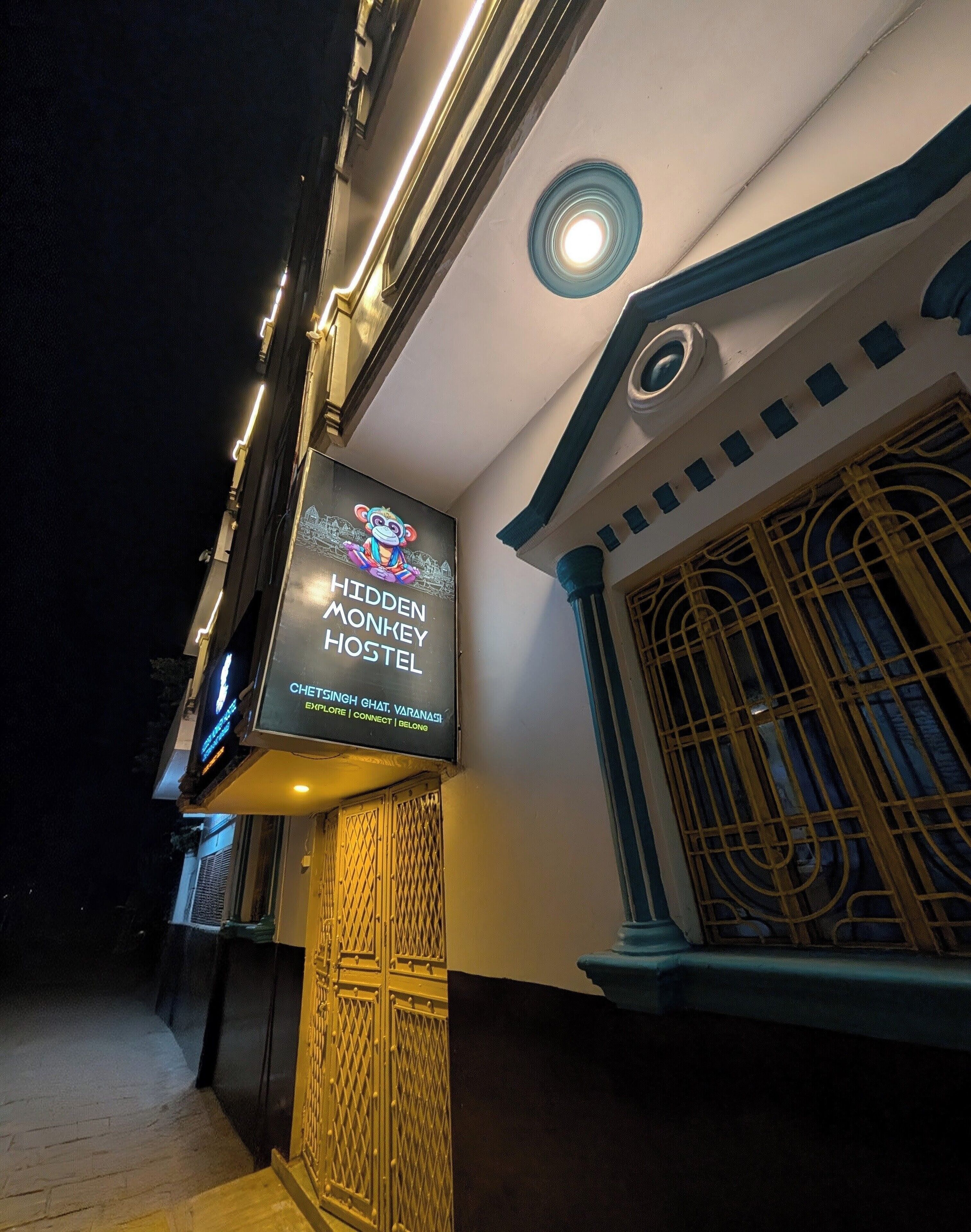 A hostel sign with a monkey illustration and the name 'Hidden Monkey Hostel'.